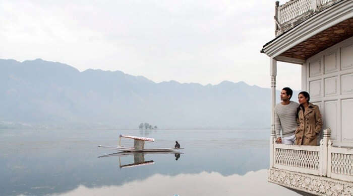 Couple enjoying unspoiled views of Dal Lake while staying in houseboat