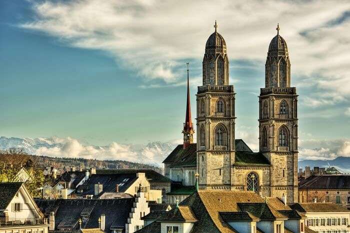 The twin towers of the Grossmunster Churche with the cloud-covered Alps in the background