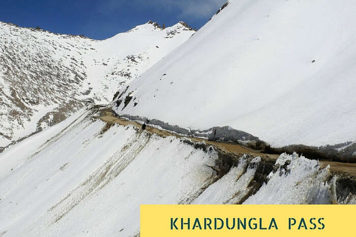 The narrow road amidst the snowclad mountains near Khardungla Pass that is the highest motorable road in the world