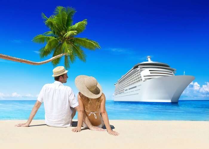 Couple gazing out at passenger ships that commute tourists between Lakshadweep and mainland