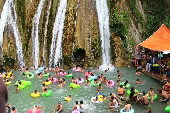 People bathing and enjoying the chilling water of Kempty Waterfalls