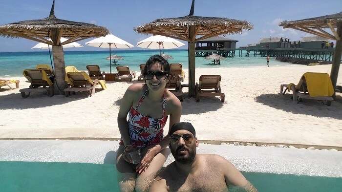 Angad and his wife by the pool at their resort