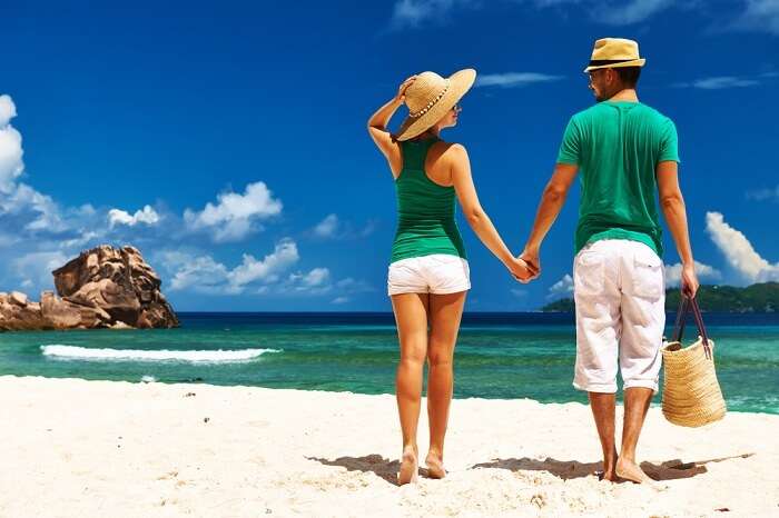 Couple relaxing on a tropical beach Anse Source d'Argent at La Digue in Seychelles