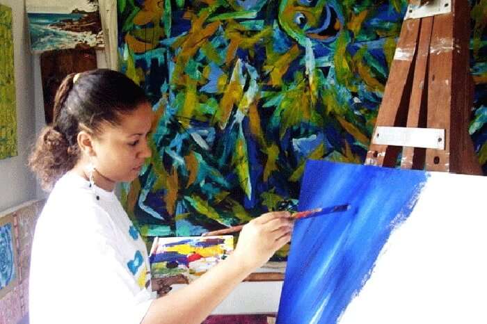 Rita Morel painting at her gallery in Seychelles