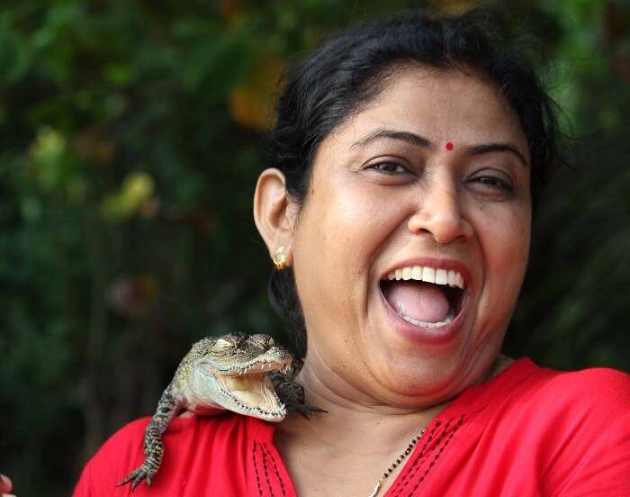 Kanikas mother with a baby crocodile on her shoulder
