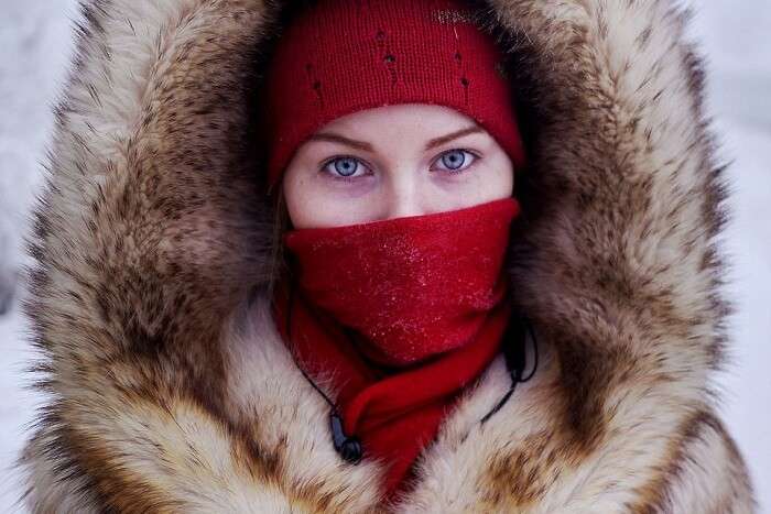 A young girl clad in thick wollens waiting for a school bus in Oymyakon during winters