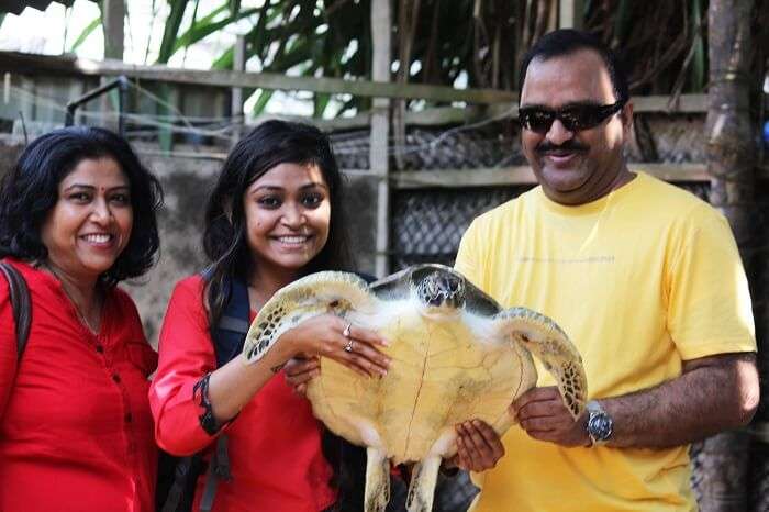 Kanika and her father with a turtle