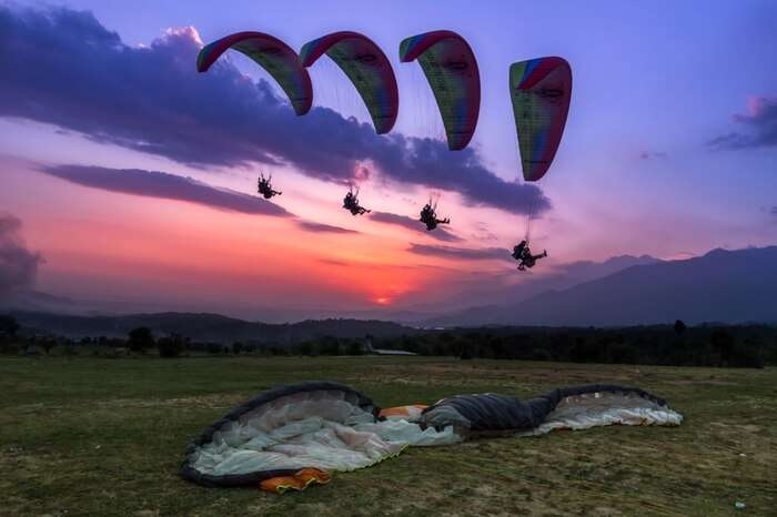 Paragliders soaring up high in the sky in Bir Billing
