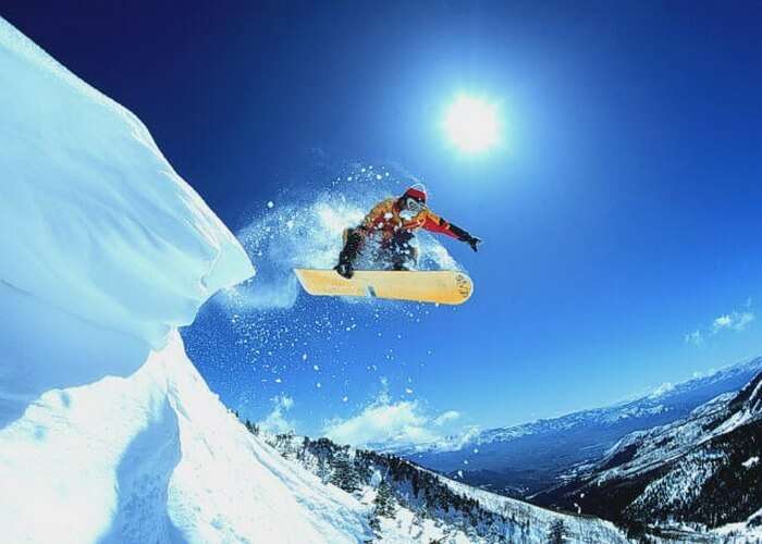 Indulge in the thrilling activity of snowboarding in Manali