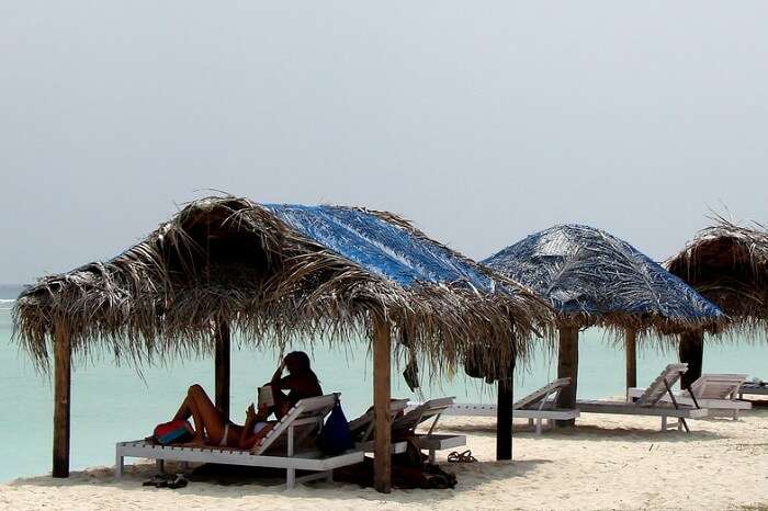 A couple relaxes at the huts on the Kadmat Beach in Lakshadweep