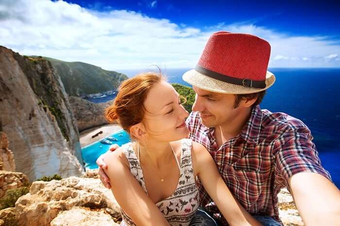 A honeymoon couple in Zakynthos with the Navagio Beach or Shipwreck Beach in the background
