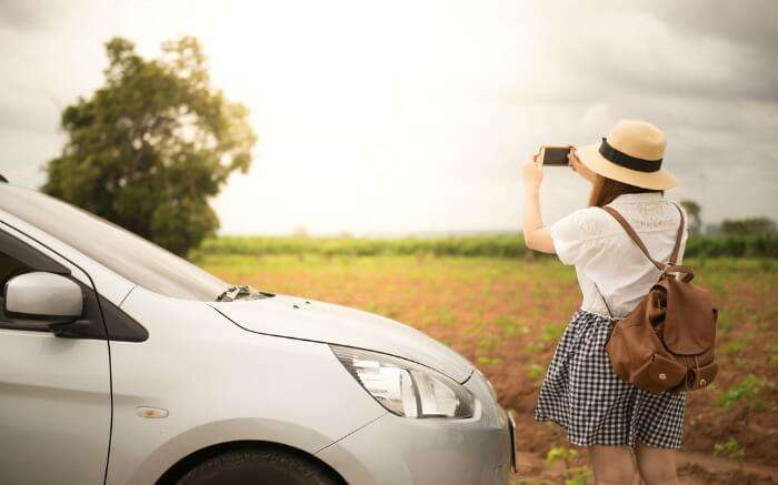 A woman clicking pictures on her road journey