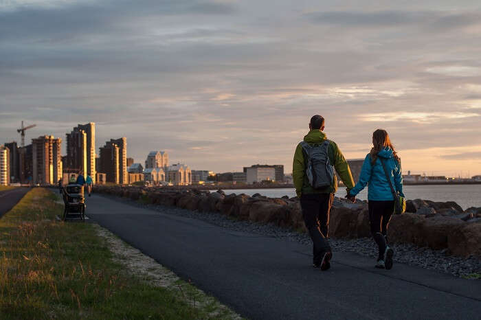 Happy sporty couple walking through the ocean coast in Reykjavik