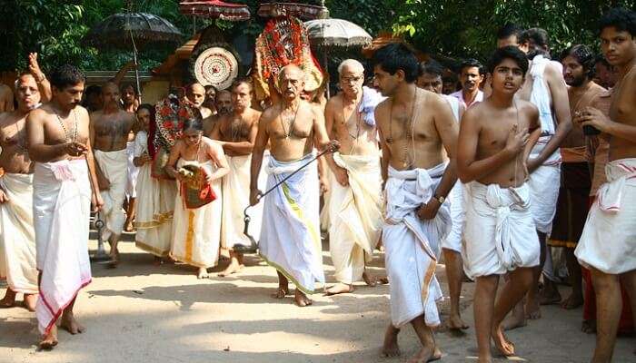 Locals and priests walk during a procession during the Mannarasala Ayilyam festival