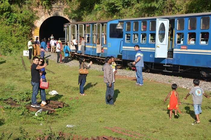 Tourists in front of the famous toy train in Mettupalayam