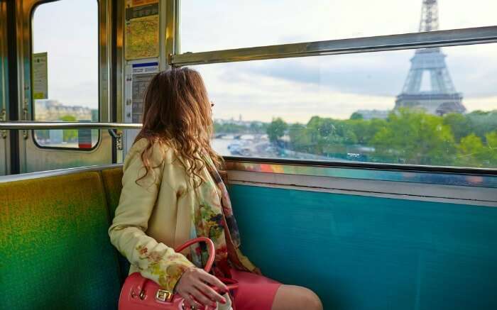  A woman traveling train going past the Eiffel Tower in Paris