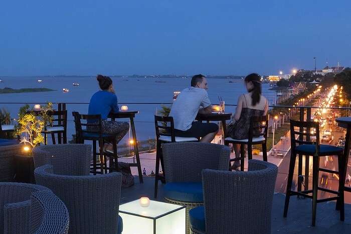 Guests enjoy drinks and snacks at a rooftop bar in Cambodia