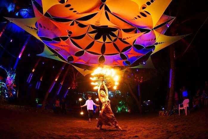 A performer dancing with fire at night at the Anjuna Beach