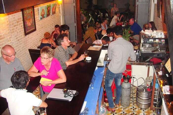 Locals at tourists interact over drinks and snacks at the Lotus Bar and Gallery in Cambodia