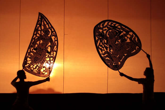 Two artists seen as shadows during one of the shadow puppetry performance in Cambodia