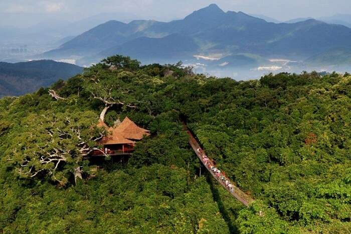 Tourists walk on the suspension bridge in Hainan
