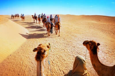 Tourists on a camel safari in the desert at Jaisalmer