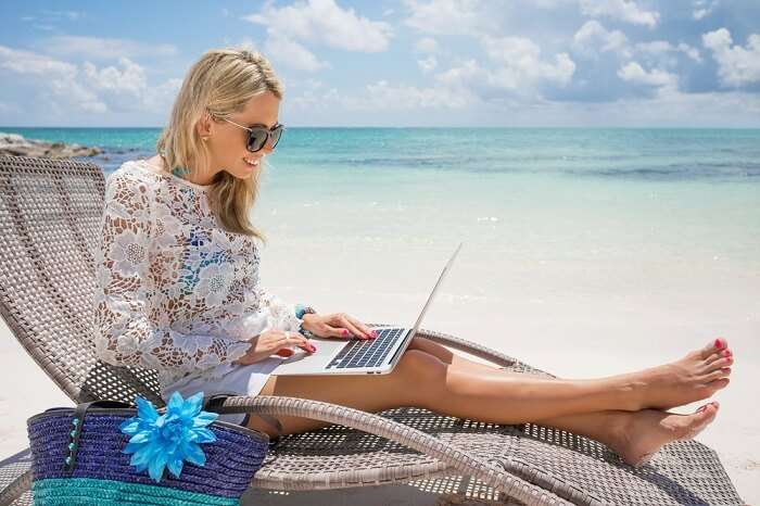 Woman working on her laptop on a beach