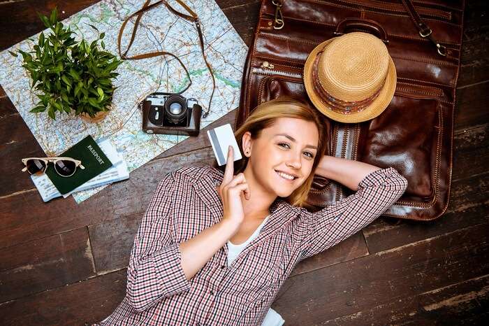 Traveler smiling and posing with a credit card