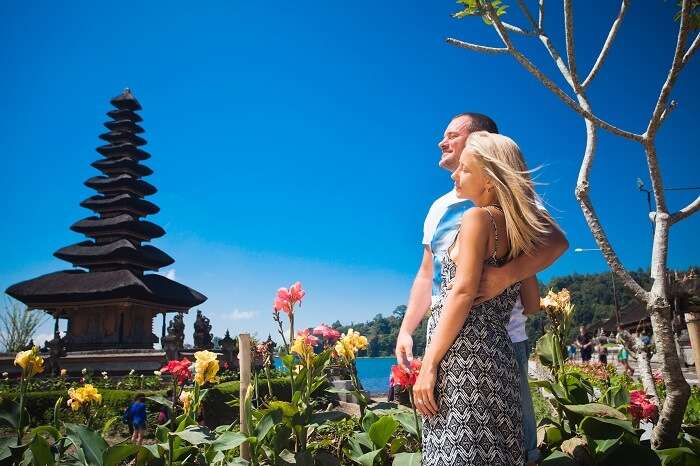 Honeymoon couple near the Balinese temple at beratan lake