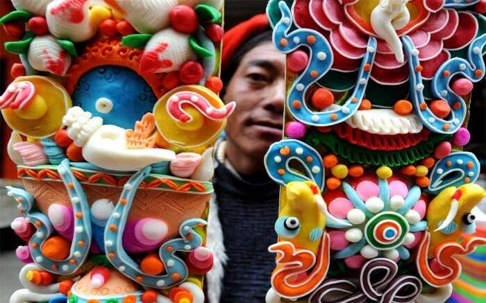 A man holding Buddhist butter sculpture which is a highlight of Tibetan losar decoration