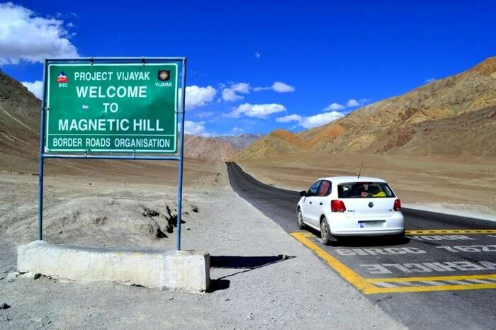 Signboard and mark on road mentioning the area under the influence of Magnetic Hill