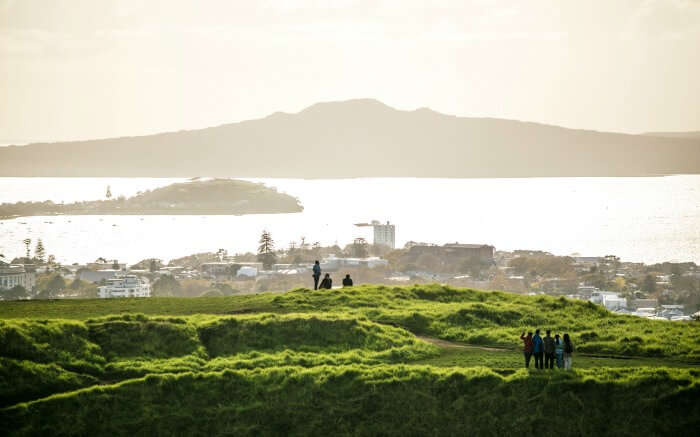 People looking at Auckland’s skyline from Mount Eden