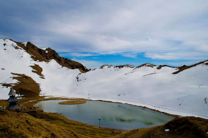 Picturesque view of Prashar Lake partially covered in snow