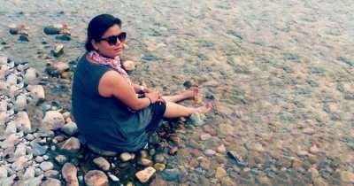 Nidhi sitting beside a stream in Jim Corbett