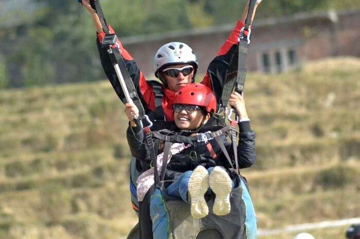 A girl landing after her paragliding adventure