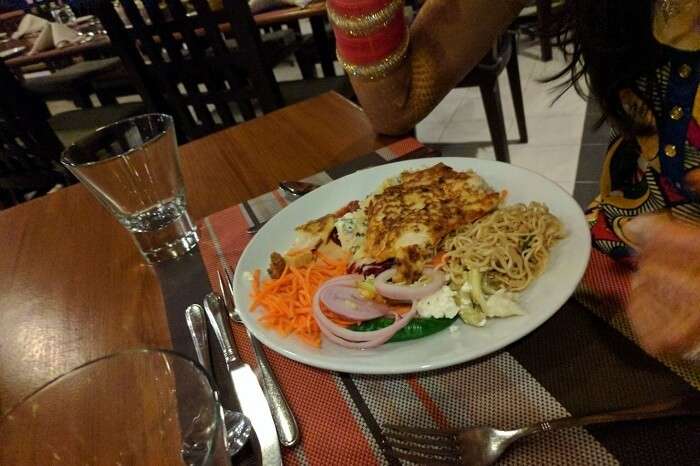 a plate full of noodles, salad and other food items