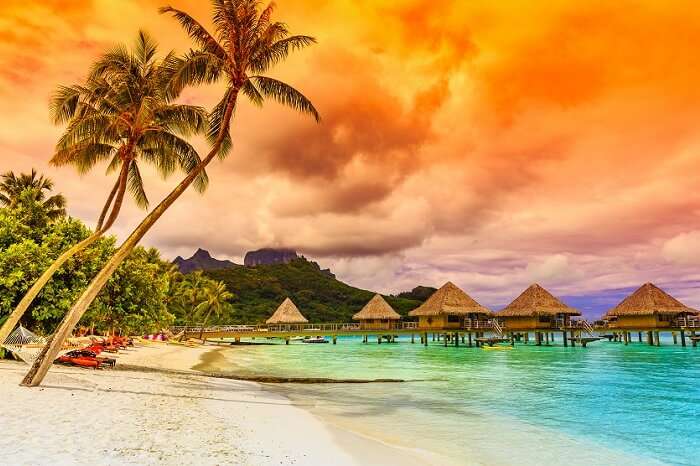 The Otemanu Mountain and the overwater villas in the backdrop of a beach at Bora Bora in French Polynesia