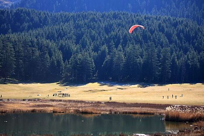 A paraglider landing at the base area in Khajjiar