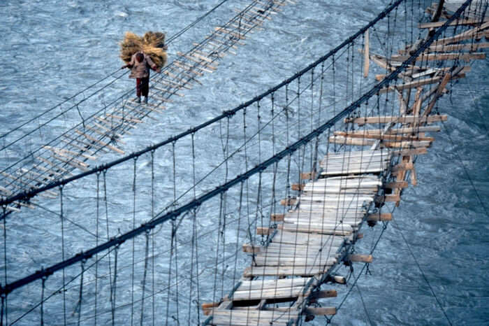A man crossing the dangerous Hussaini Hanging Bridge in Pakistan