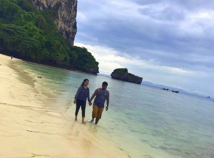Jegen and his wife take a walk on a beach of Thailand