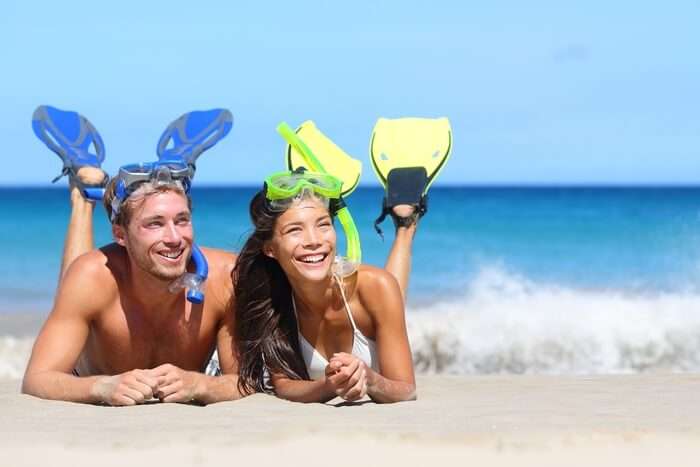 A couple relaxing on a beach after snorkeling in Hawaii