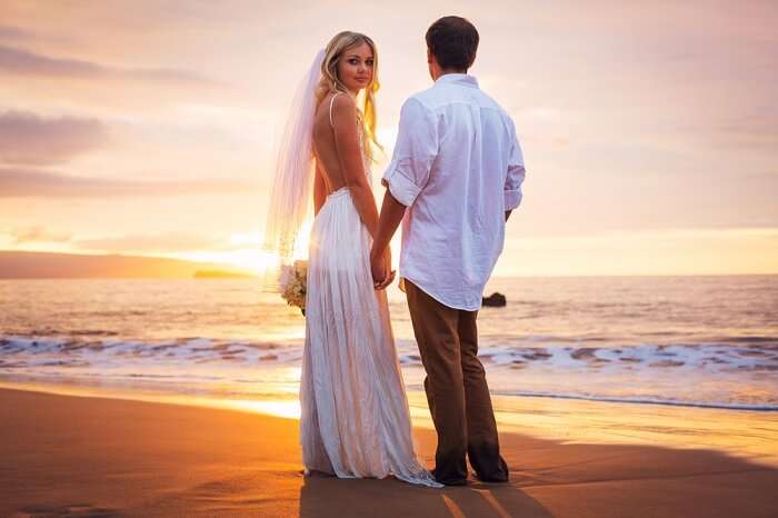 A sunset shot of a couple on a beach after renewing the wedding vows in Hawaii