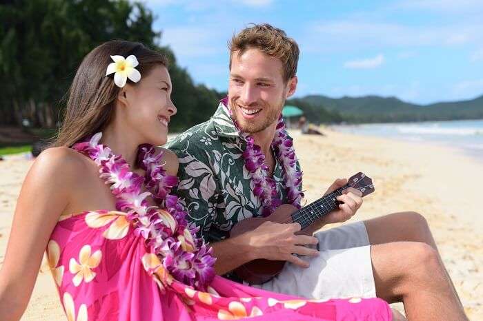  A couple relaxing on a sandy beach of Hawaii