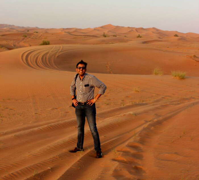 Standing in the vast, golden Arabian desert for our Desert Safari tour