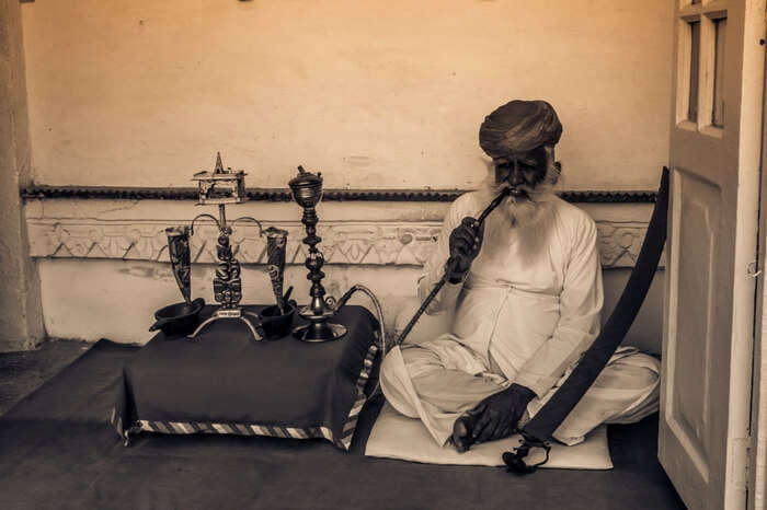 Man smoking pipe inside Mehrangarh Fort