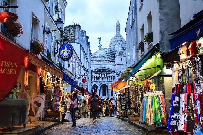 Tourists and Parisians walking around the shopping street of Montmartre in Paris