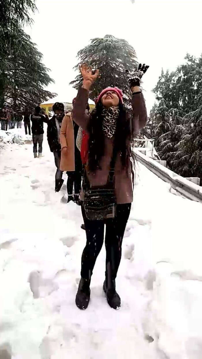 Girl playing with snow in Dalhousie