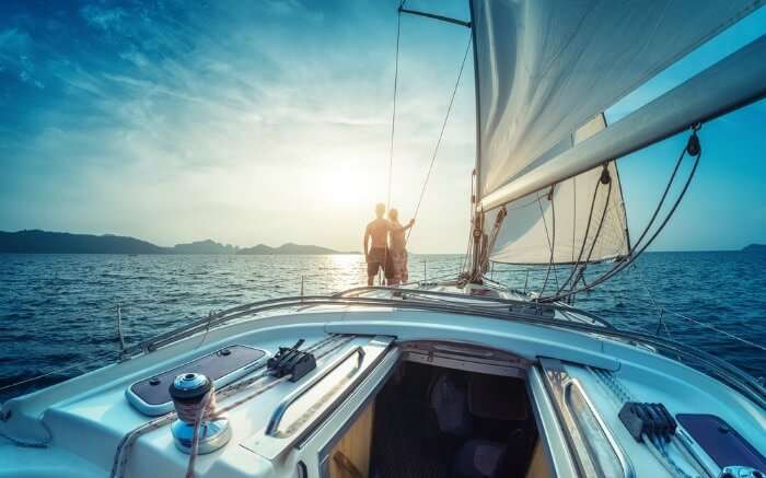 A couple facing sun onboard a yacht