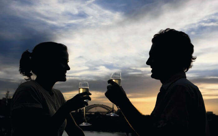 A couple enjoying wine with Sydney Harbour in background 