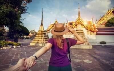 A woman in hat posing in front of Wat Pho